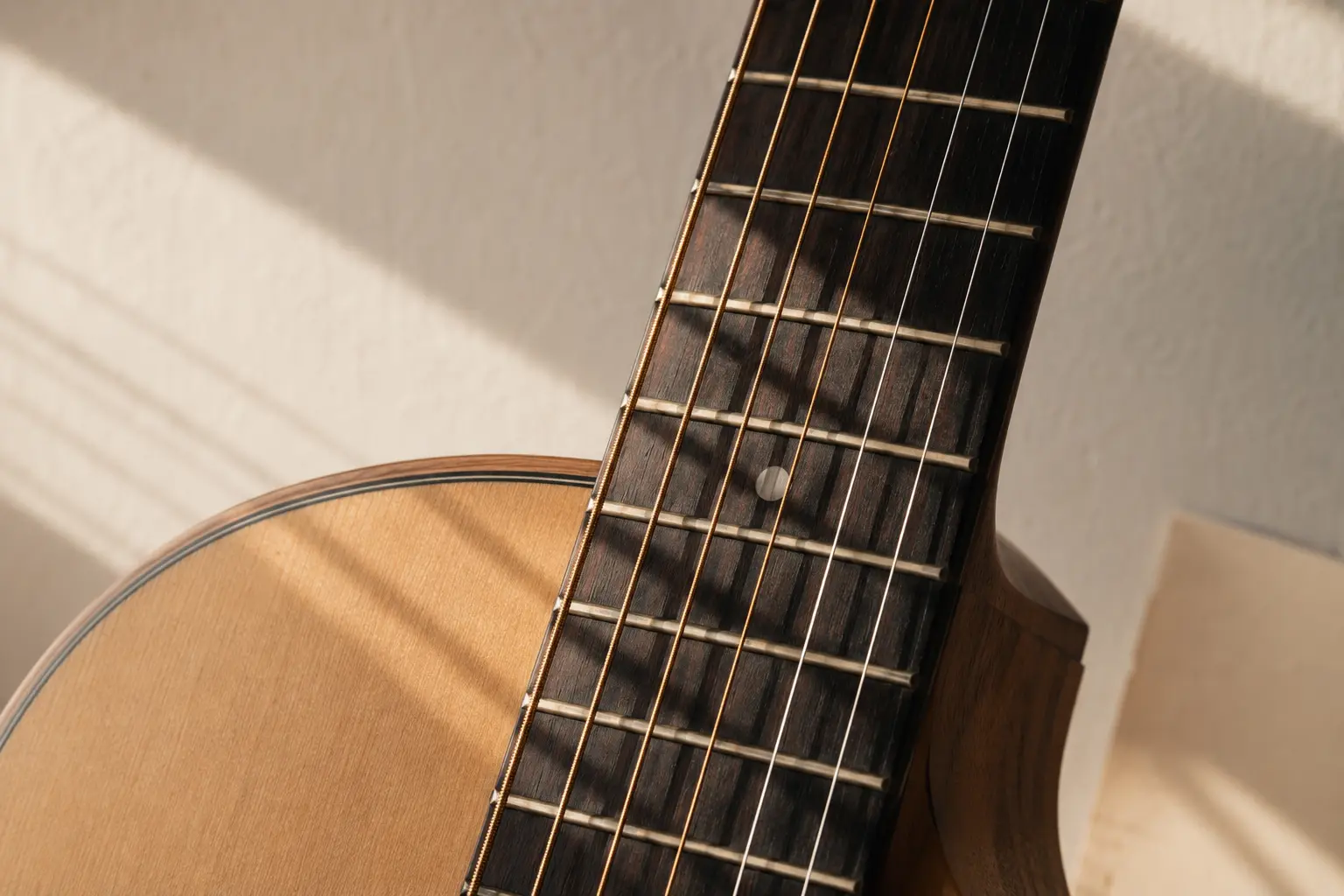 Perspektive entlang eines Gitarrenhalses auf eine spielende Hand und eine zuhörende Person